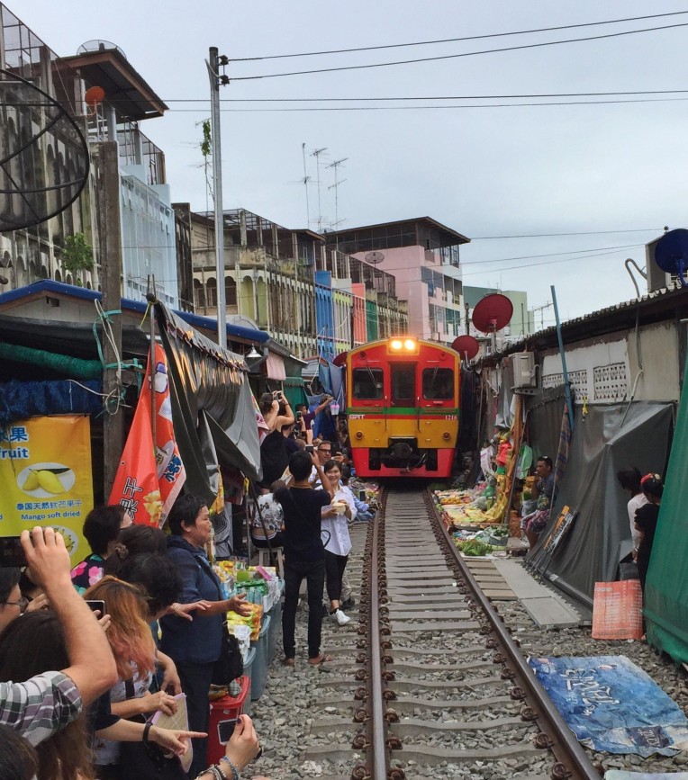The train slowly creeps through the Maeklong Railway Market several times a day